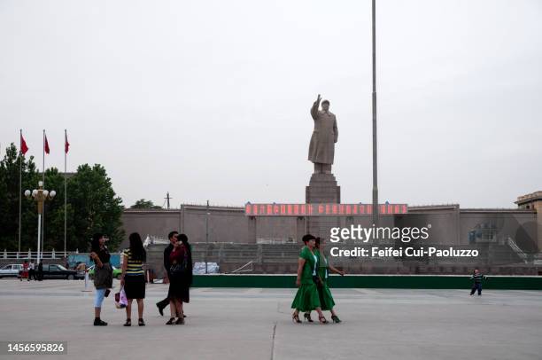group of people walking in front of mao zedong sculpture at kashgar - ouïgour photos et images de collection