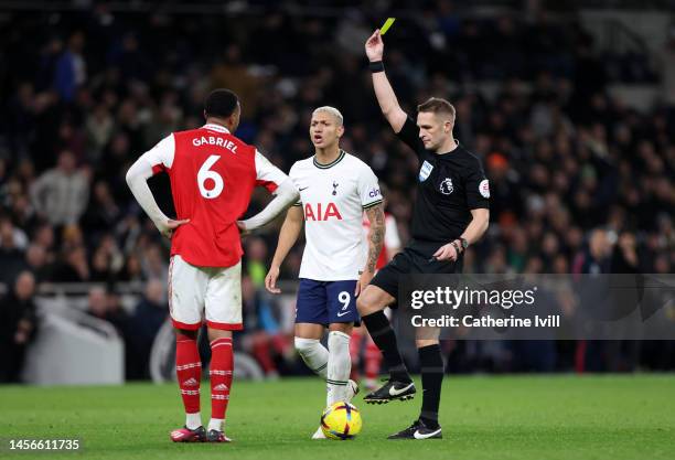 Referee Craig Pawson shows a yellow card to Gabriel of Arsenal during the Premier League match between Tottenham Hotspur and Arsenal FC at Tottenham...