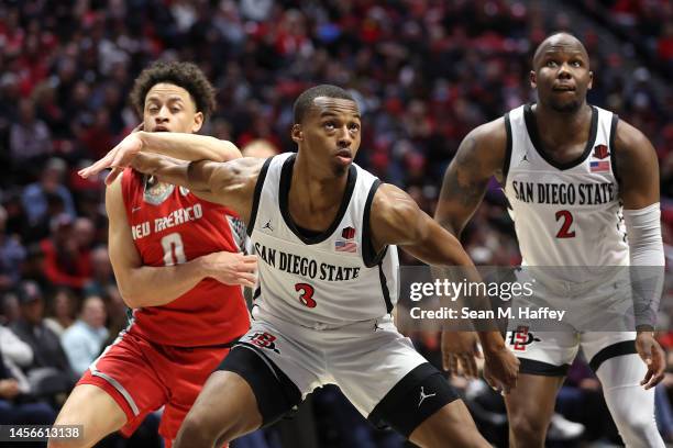 Micah Parrish and Adam Seiko of the San Diego State Aztecs rebound against KJ Jenkins of the New Mexico Lobos during the second half of a game at...