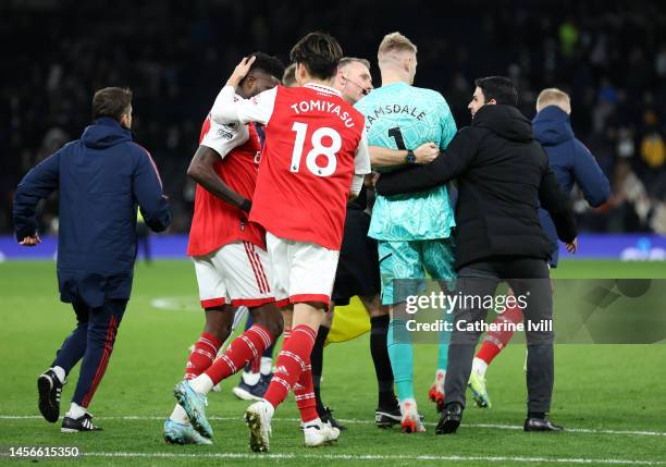 Mikel Arteta walks Aaron Ramsdale of Arsenal towards the Arsenal fans to celebrate after the team's victory during the Premier League match between...