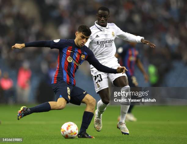 Pedri of FC Barcelona battles for possession with Ferland Mendy of Real Madrid during the Super Copa de Espana Final match between Real Madrid and FC...
