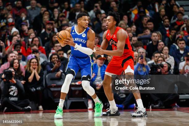Giannis Antetokounmpo of the Milwaukee Bucks dribbles against Scottie Barnes of the Toronto Raptors during the first half of their NBA game at...