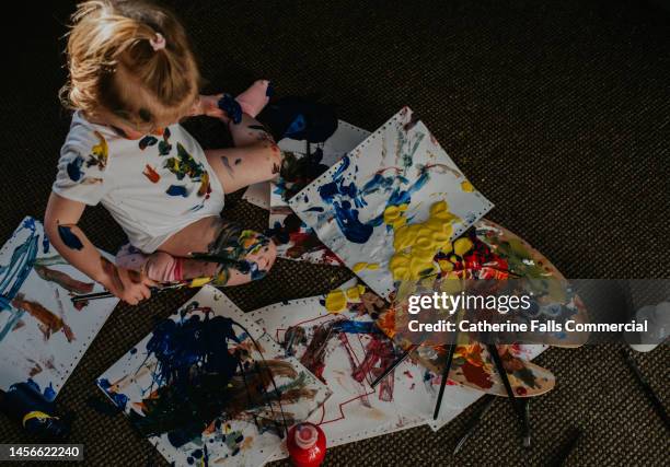 top down image of a toddler creating a huge mess with primary coloured paints - toddler stock pictures, royalty-free photos & images