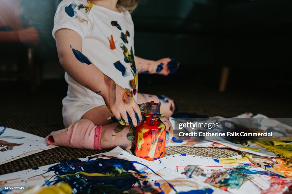 Twin girls create a huge mess with primary coloured paints
