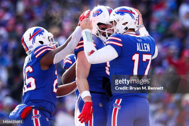 Devin Singletary, Dawson Knox and Josh Allen of the Buffalo Bills celebrate on the field during the second quarter of the game against the Miami...