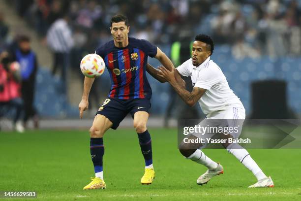 Robert Lewandowski of FC Barcelona is challenged by Eder Militao of Real Madrid during the Super Copa de Espana Final match between Real Madrid and...