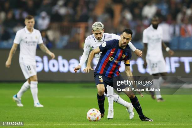 Sergio Busquets of FC Barcelona is challenged by Federico Valverde of Real Madrid during the Super Copa de Espana Final match between Real Madrid and...