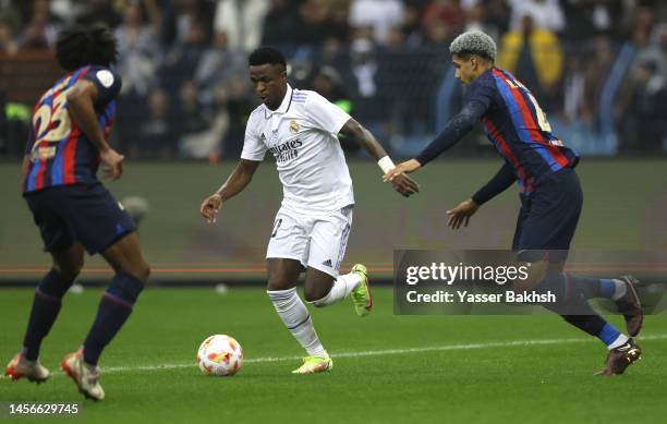Vinicius Junior of Real Madrid is challenged by Ronald Araujo of FC Barcelona during the Super Copa de Espana Final match between Real Madrid and FC...