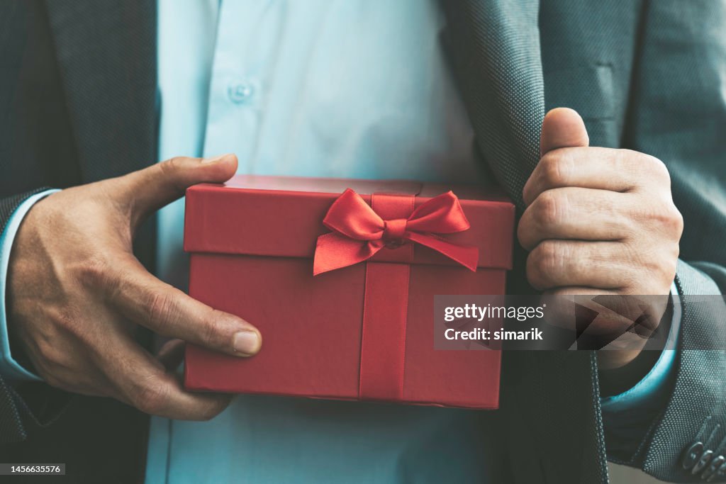 Mann gibt Geschenkbox