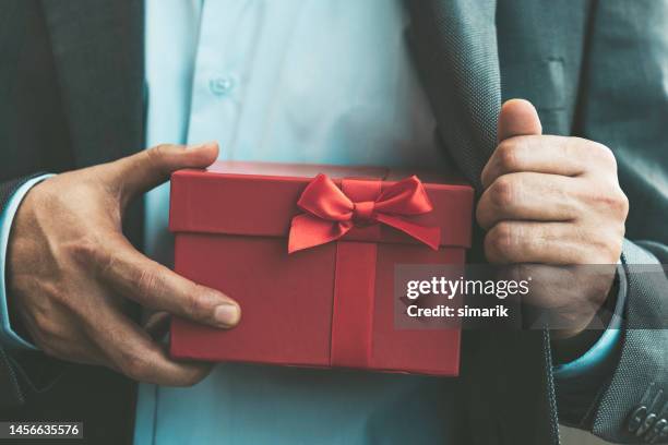 hombre dando caja de regalo - corruption fotografías e imágenes de stock