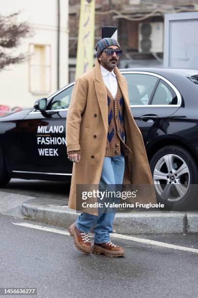 Guest is seen wearing a long overcoat, cardigan over a button shirt and Missoni beanie outside the Etro show during the Milan Menswear Fall/Winter...