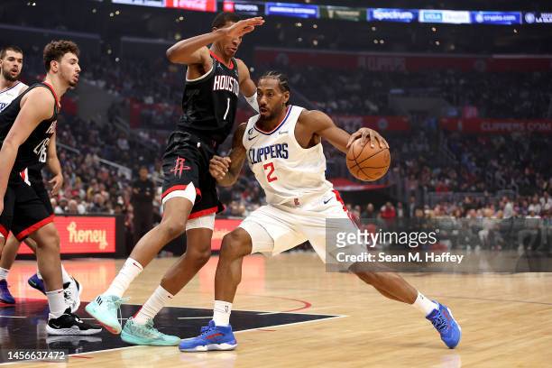 Kawhi Leonard of the LA Clippers dribbles into the defense of Jabari Smith Jr. #1 of the Houston Rockets during the first half of a game at...
