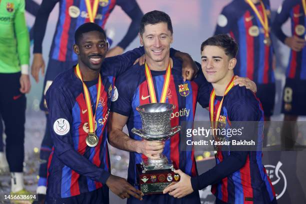 Ousmane Dembele, Robert Lewandowski and Gavi of FC Barcelona celebrate with the Super Copa de Espana trophy after the team's victory during the Super...
