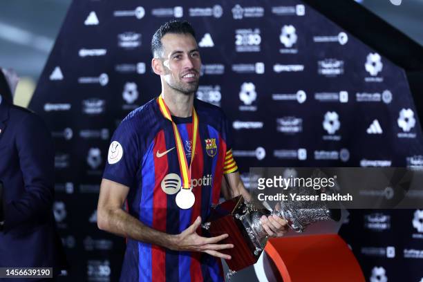 Sergio Busquets of FC Barcelona receives the Super Copa de Espana trophy after the team's victory in the trophy presentation during the Super Copa de...