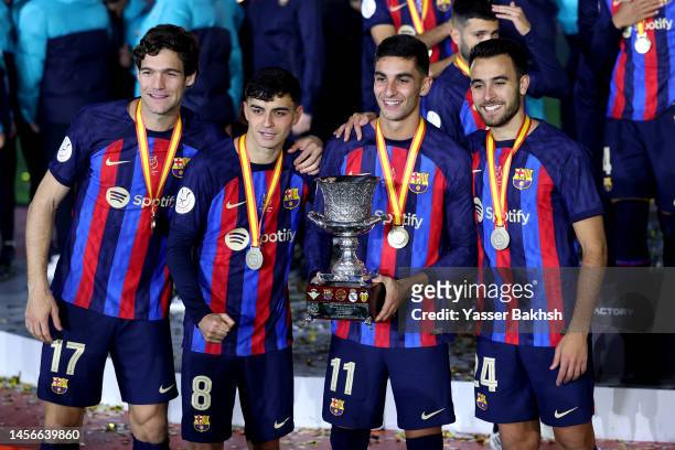 Marcos Alonso, Pedri, Ferran Torres and Eric Garcia of FC Barcelona pose for a photo with the Super Copa de Espana trophy after the team's victory...