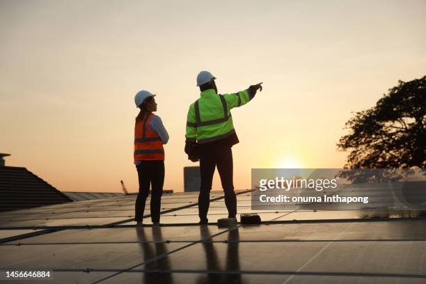 green energy technology solar cell, project engineer and service technician work for   solar cell installation and service on the roof of factory - panel solar stock pictures, royalty-free photos & images