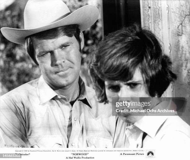 Glen Campbell and Kim Darby stand together staring forward in a scene from the film 'Norwood', 1969.