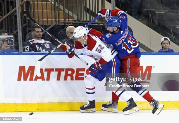 Alexis Lafreniere of the New York Rangers ties up Justin Barron of the Montreal Canadiens during the second period at Madison Square Garden on...