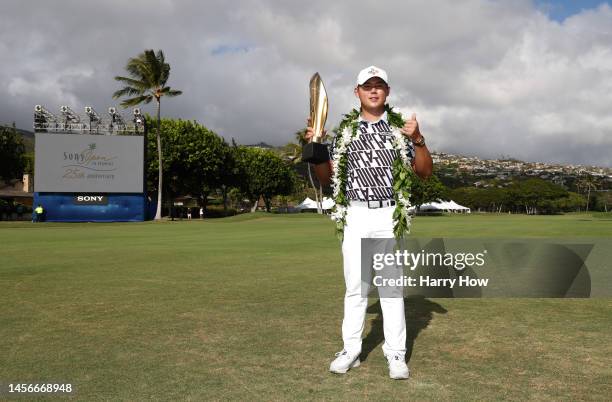 Si Woo Kim of South Korea poses with the trophy after putting in to win on the 18th green during the final round of the Sony Open in Hawaii at...