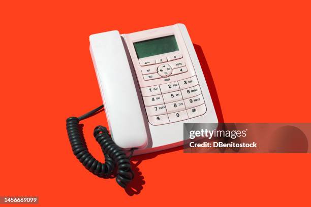 white retro telephones, with cord, on a red background. concept of old, telephony, landline, talk, distance, listen, switchboard and customer service. - teléfono con cable fotografías e imágenes de stock