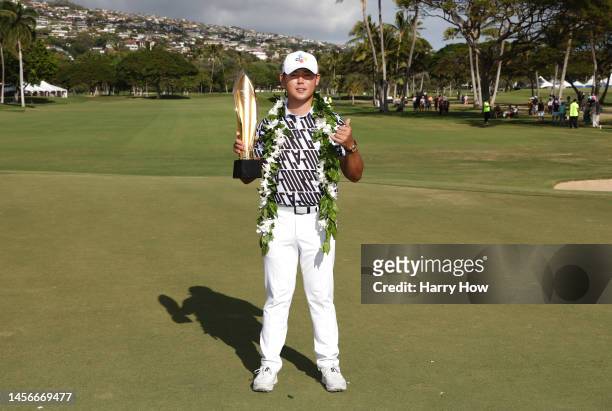 Si Woo Kim of South Korea poses with the trophy after putting in to win on the 18th green during the final round of the Sony Open in Hawaii at...