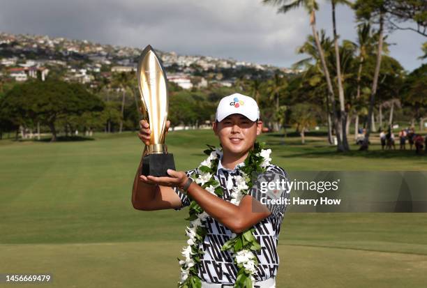 Si Woo Kim of South Korea poses with the trophy after putting in to win on the 18th green during the final round of the Sony Open in Hawaii at...