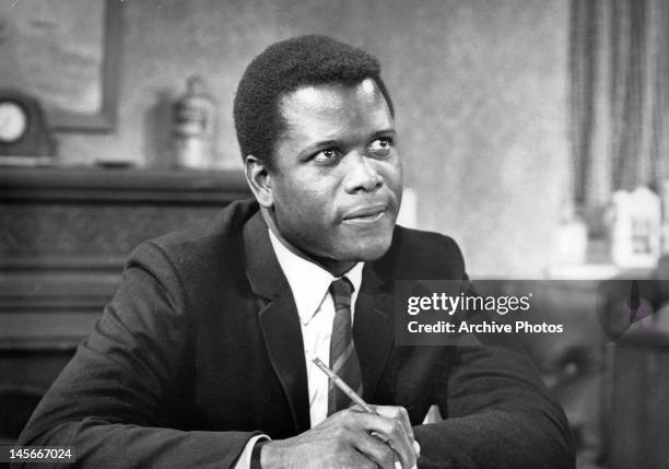 Sidney Poitier sitting with pencil while looking up in a scene from the film 'To Sir, With Love', 1967.
