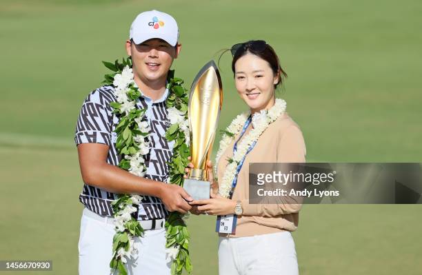Si Woo Kim of South Korea poses with his wife Ji Hyun Oh and the trophy after putting in to win on the 18th green during the final round of the Sony...