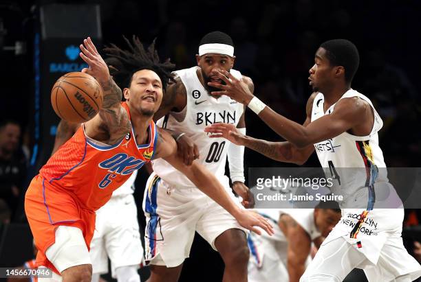 Jaylin Williams of the Oklahoma City Thunder battles Royce O'Neale and Edmond Sumner of the Brooklyn Nets for a loose ball during the game at...