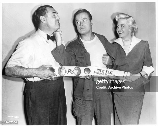 Jack Dempsey receives uppercut to the chin from Bob Hope as Marilyn Maxwell smiles in a scene from the film 'Off Limits', 1953.