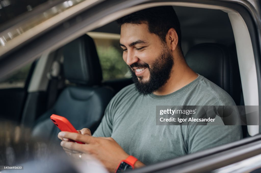Motorista estacionado consultando APP em smartphone