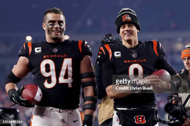 Sam Hubbard and Joe Burrow of the Cincinnati Bengals celebrate as they walk off the field after defeating the Baltimore Ravens in the AFC Wild Card...