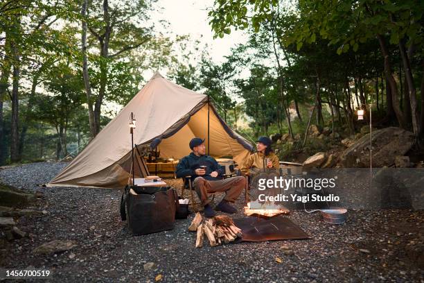 couple enjoys camping at a campground in the woods. - couple paysage asie photos et images de collection