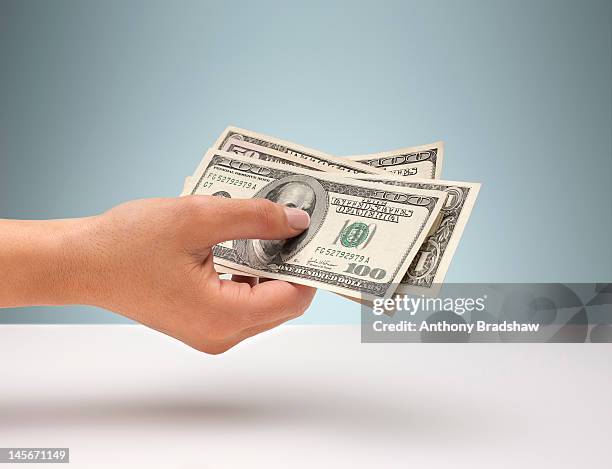 hand holding american currency - holding cash stock pictures, royalty-free photos & images