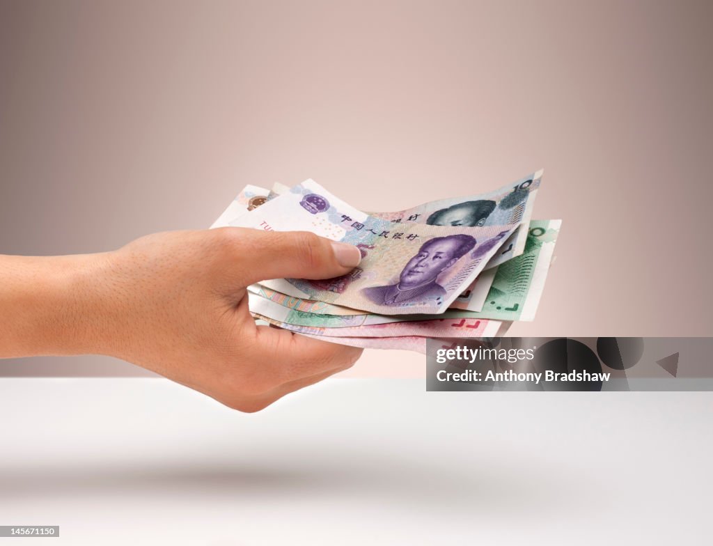 Hand holding Chinese Yuan currency