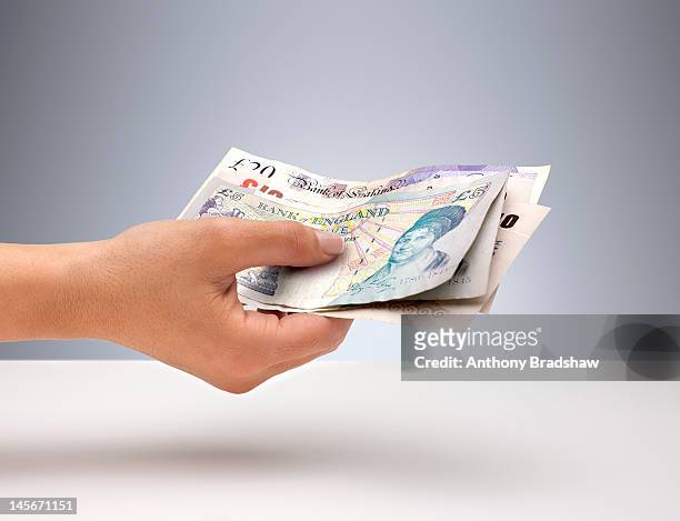hand holding english currency - british pound sterling stock pictures, royalty-free photos & images