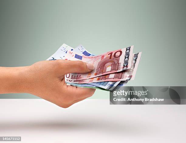 hand holding euro currency - eu valuta foto e immagini stock