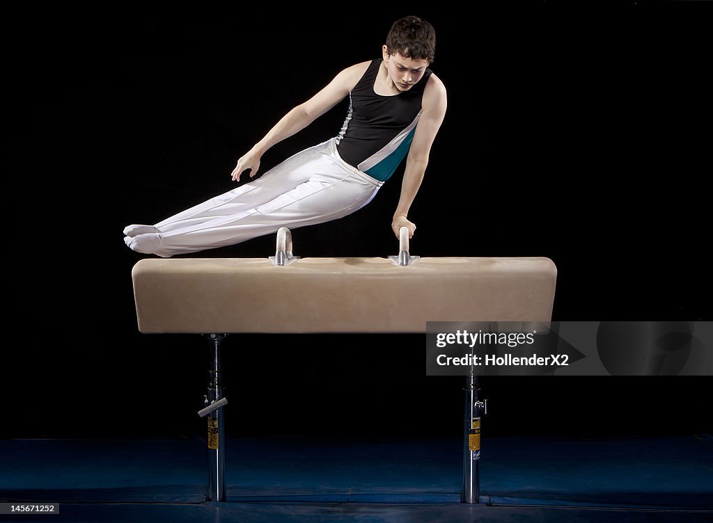 Young gymnast performs on pommel horse