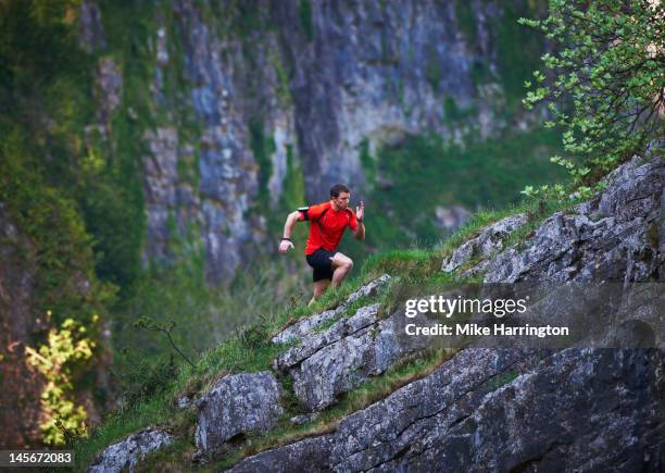 mountain runner running up steep incline - sport performance stock-fotos und bilder