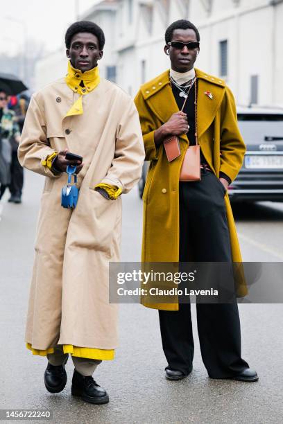 Model Mamadou Diagne is seen wearing a beige and yellow trench coat, Tourek Hadim is seen wearing a mustard military coat and black suit pants...