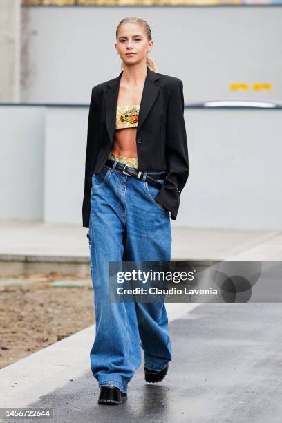 Caro Daur is seen wearing a pale yellow cropped top, a black blazer jacket and blue denim large pants outside the Etro show during the Milan Menswear...