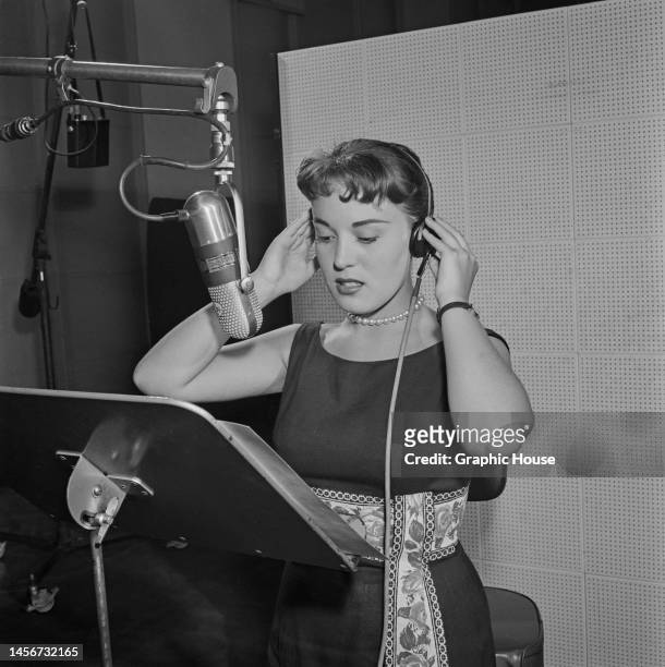 American singer Jennie Smith adjusts her headset during the recording sessions for her debut album, 'Jennie', at RCA Victor Studios in New York City,...