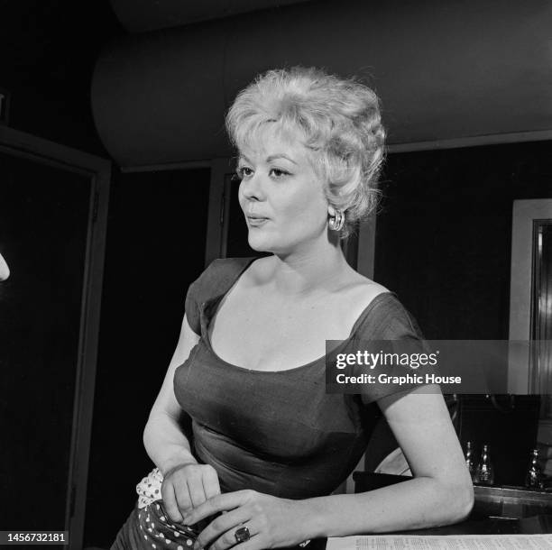 Belgian-American actress and dancer Monique van Vooren , wearing a cap sleeve dress with a scooped neckline, in an recording studio, United States,...