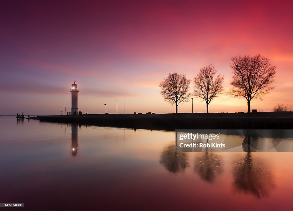 Harbor jetty and lighthouse at sunset