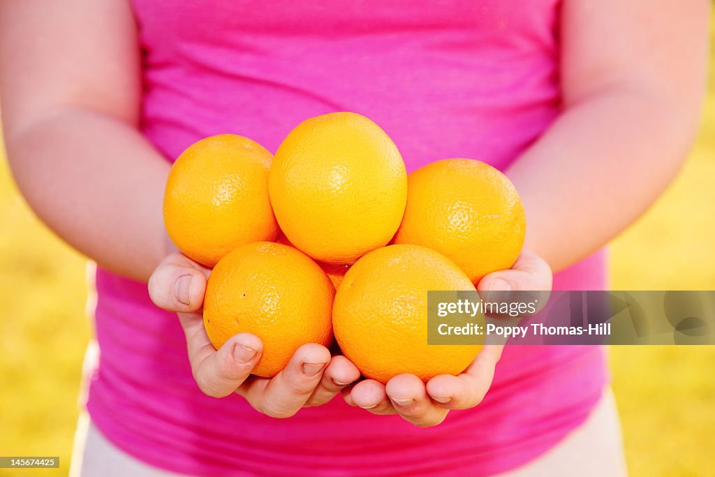 Girl holding oranges