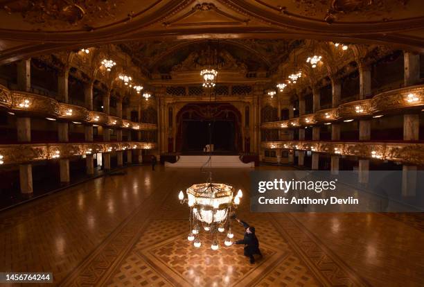 Workman dusts a one tonne Edwardian chandelier lowered into the ballroom at Blackpool Tower ahead of its week long annual clean on January 16, 2023...