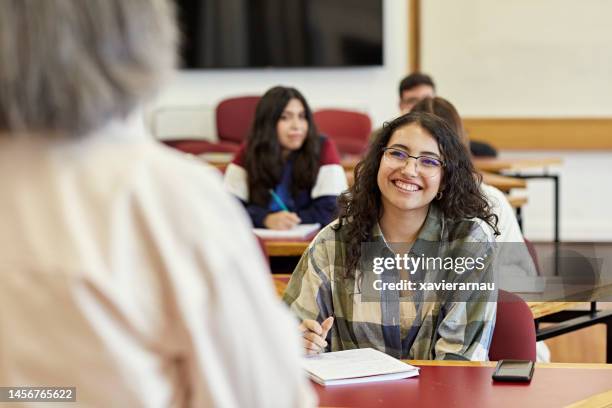 smiling student and teacher interacting in class - sala de aula de universidade imagens e fotografias de stock