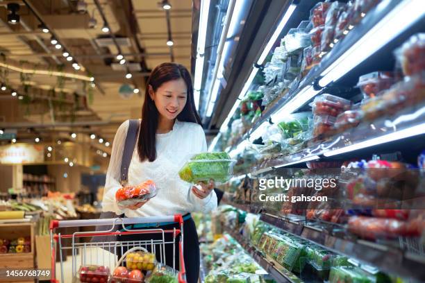sonriente mujer en supermercado - asian food fotografías e imágenes de stock