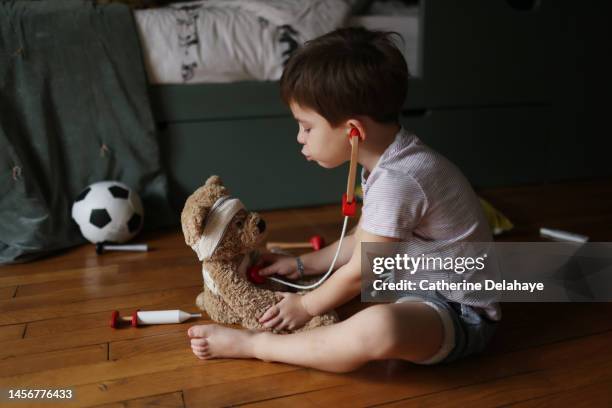 a 4 year old boy playing doctor with his teddy bear in his bedroom - screening of ill see you in my dreams arrivals stockfoto's en -beelden