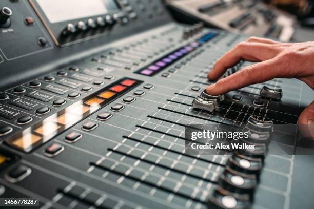 person moving slider on professional sound mixing desk - dj desk stock-fotos und bilder